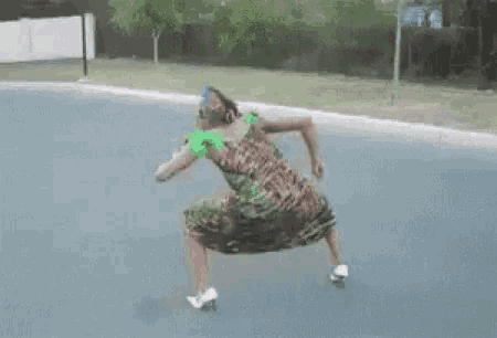 a woman in a dress and high heels is dancing on the street .