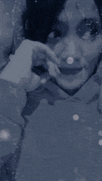 a close up of a person 's face with snow falling around it