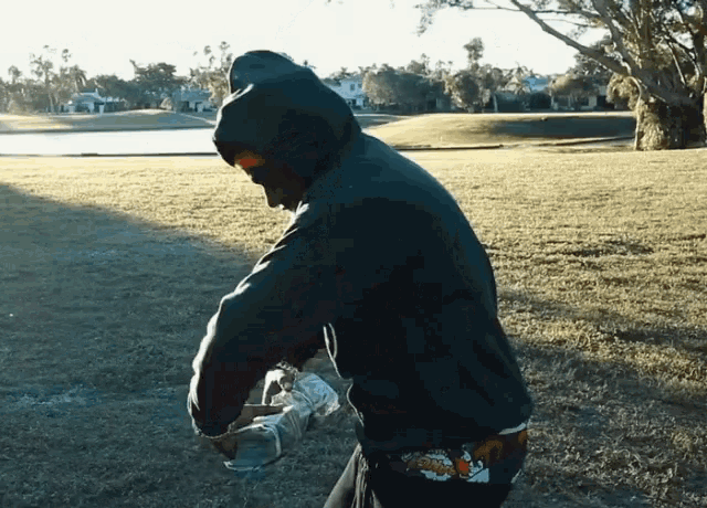 a man in a hoodie holds a bottle of water in his hand