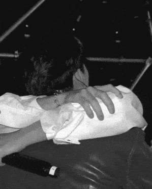 a black and white photo of a person holding another person 's shoulder