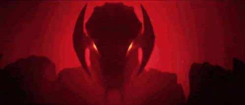 a close up of a robot with red eyes and horns .
