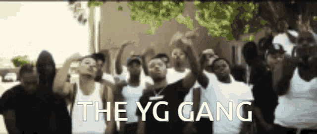 a group of young men are standing in front of a building with the words the yg gang written on the bottom
