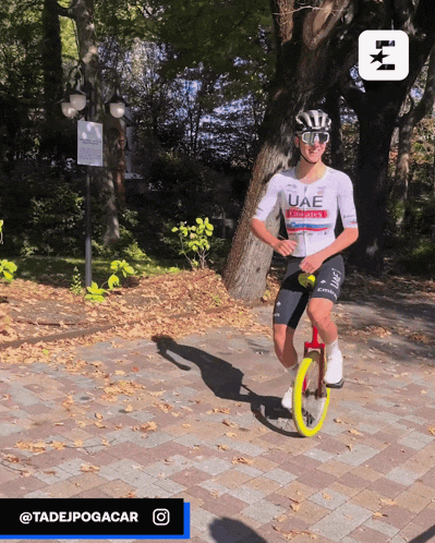 a man wearing a uae shirt is riding a bike
