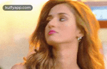 a close up of a woman 's face with a pink lip and earrings .