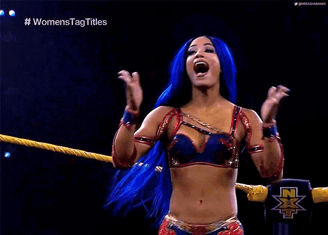 a woman with blue hair is standing in a ring and saying i made nxt