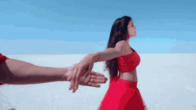 a woman in a red dress is being held by a man 's arm