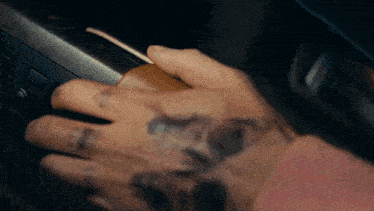 a person with a tattoo on their hand is pressing a button on a car
