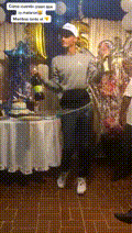 a man is standing in front of a table with a bottle of wine in his hand .