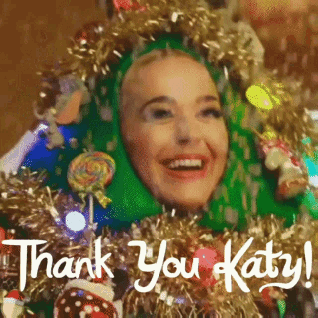 a woman in a green costume is smiling and says thank you katy .