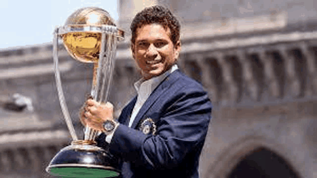 a man in a suit is holding a trophy in his hand .