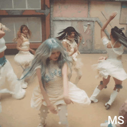 a group of women are dancing in front of a sign that says ms on it