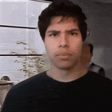 a man in a black shirt is making a funny face