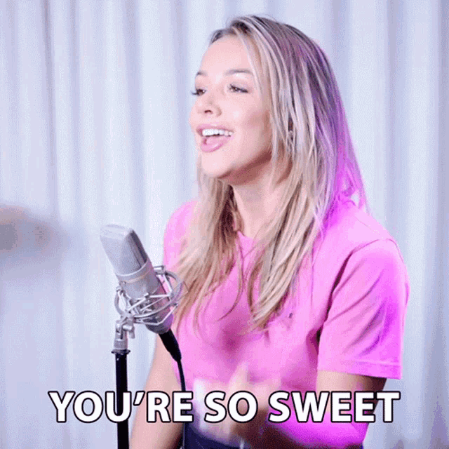 a woman singing into a microphone with the words " you 're so sweet " above her