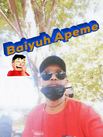 a man wearing sunglasses and a red shirt stands in front of a sign that says baiyuh apeme