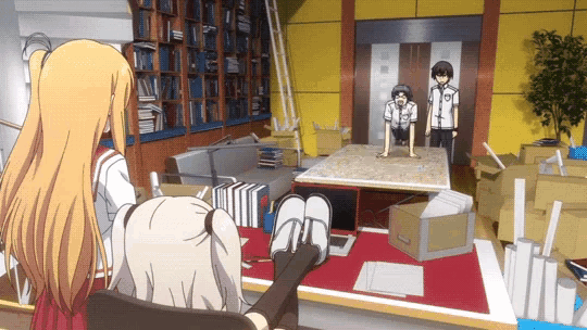 a girl sits in a chair in front of a table with boxes on it