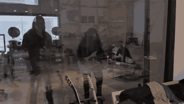 a woman playing a guitar in a room with a reflection