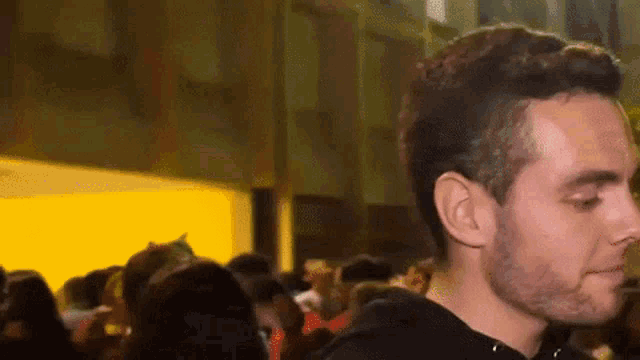 a man with a beard stands in front of a crowd