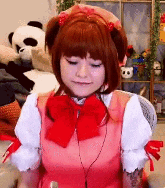 a woman wearing a pink and white dress with a red bow is sitting in front of stuffed animals .