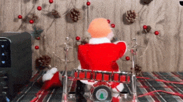 a santa claus toy is playing drums on a table .