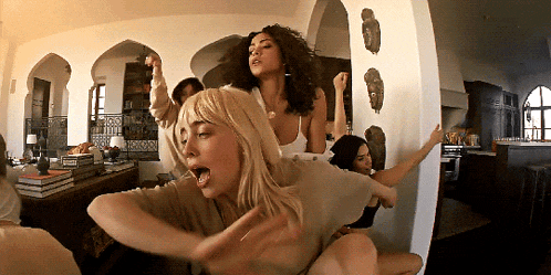 a group of women are dancing in a room with arches