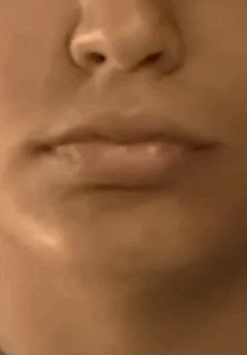 a close up of a woman 's lips and nose in a blurry photo