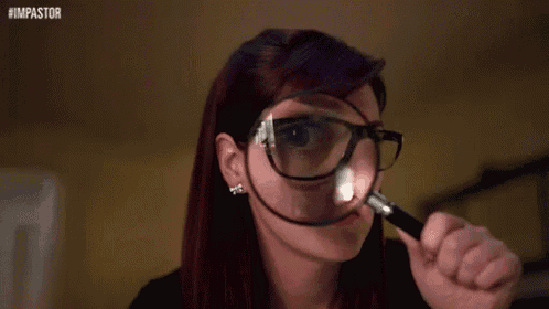 a woman wearing glasses is looking through a magnifying glass on her nose .