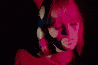 a close up of a woman 's face with pink flowers projected on her face