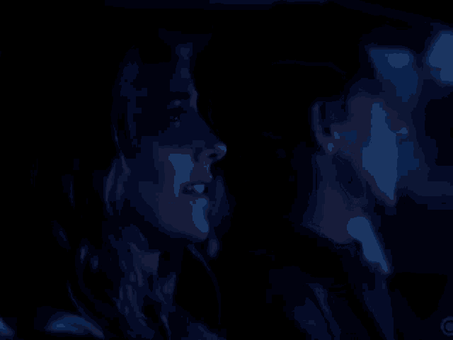 a car is driving down a road at night with a dark blue sky in the background .