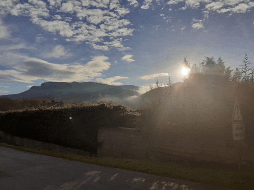 the sun shines brightly through the clouds over a mountain