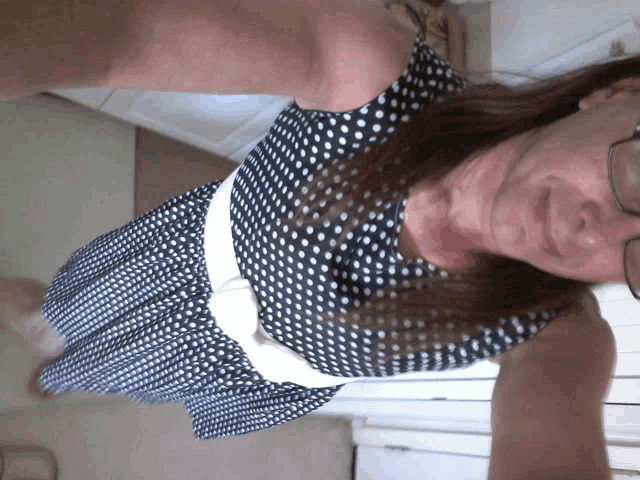 a woman wearing a black and white polka dot dress