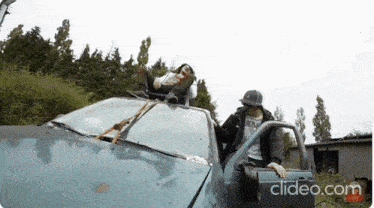 a man is sitting on the roof of a car with a clipeo.com watermark