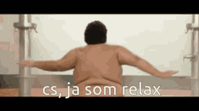 a naked man is sitting in a bathtub with his arms outstretched and says cs ja som relax
