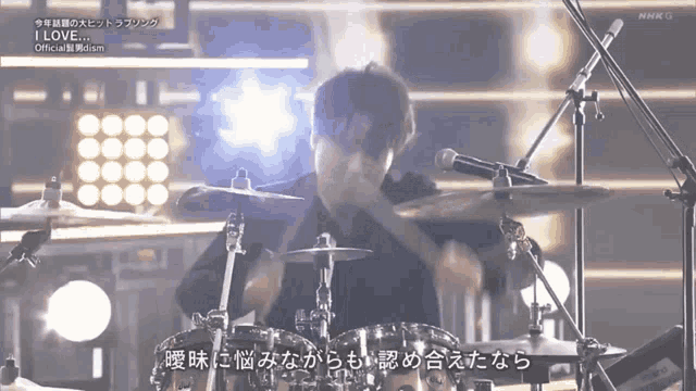 a man playing drums in front of a microphone with the words i love on the bottom