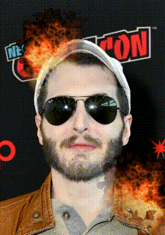 a man wearing sunglasses stands in front of a new york con sign