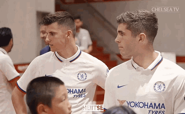 two soccer players wearing yokohama tyres jerseys