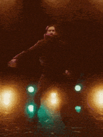 a blurry picture of a person standing in front of a green light