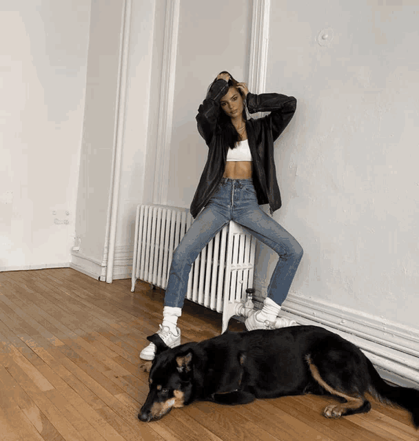 a woman sits on a radiator next to a dog