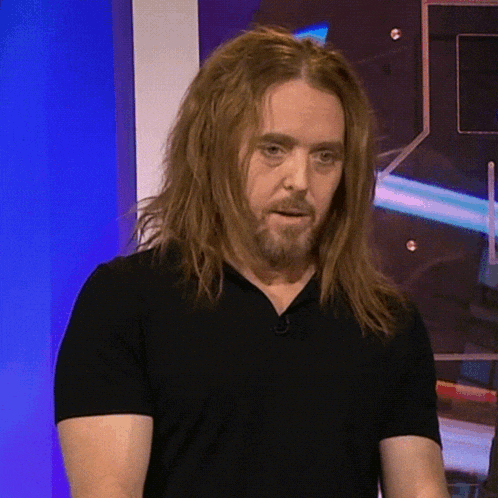 a man with long hair and a beard is wearing a black t-shirt