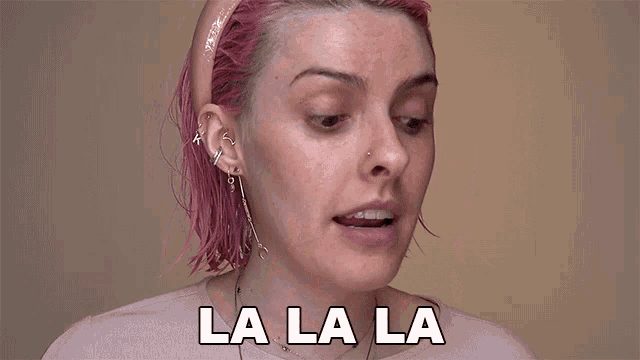 a woman with pink hair is singing la la la with her mouth open