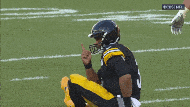 a football player with the number 5 on his jersey is kneeling down on the field