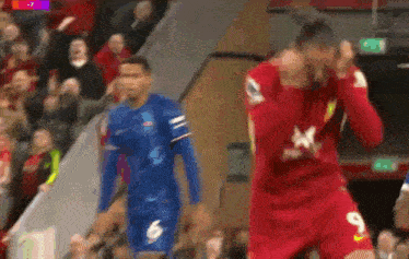 a soccer player in a red jersey with the number 9 on it is walking on the field .