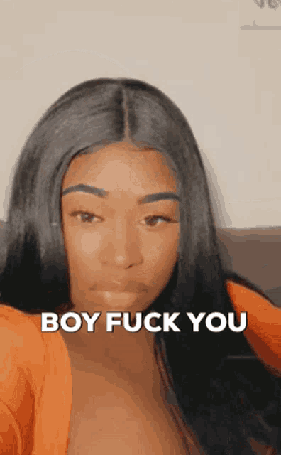 a woman is taking a selfie with the words boy fuck you on her face .