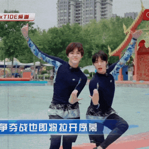 two young men are standing next to each other in front of a sign that says " xtide "