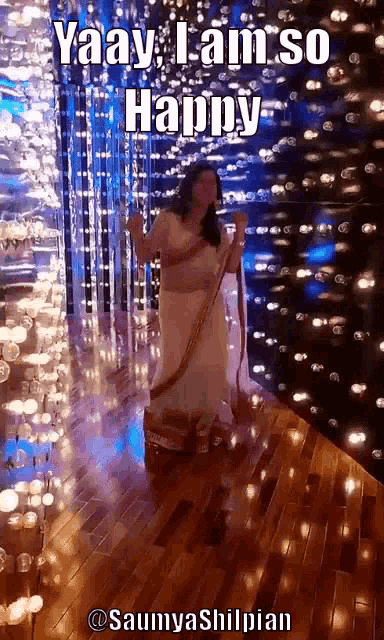 a woman in a white dress is dancing in front of a wall of lights
