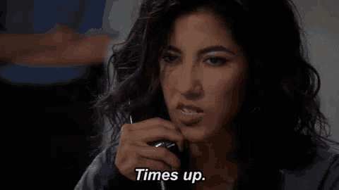 a close up of a woman 's face with the words `` times up '' written next to her .