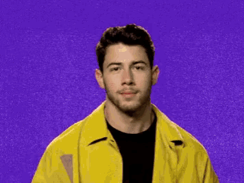 a man in a yellow shirt is smiling and winking at the camera .