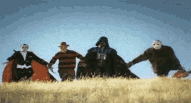 a group of people in costumes are holding hands in a field