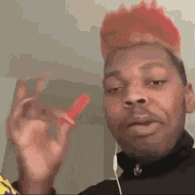 a man with red hair is wearing headphones and holding a red object .