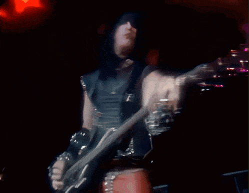 a blurry picture of a person playing a guitar in the dark