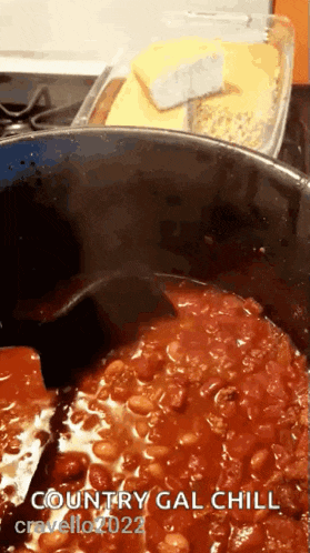 a pot of country gal chili is being cooked on a stove top